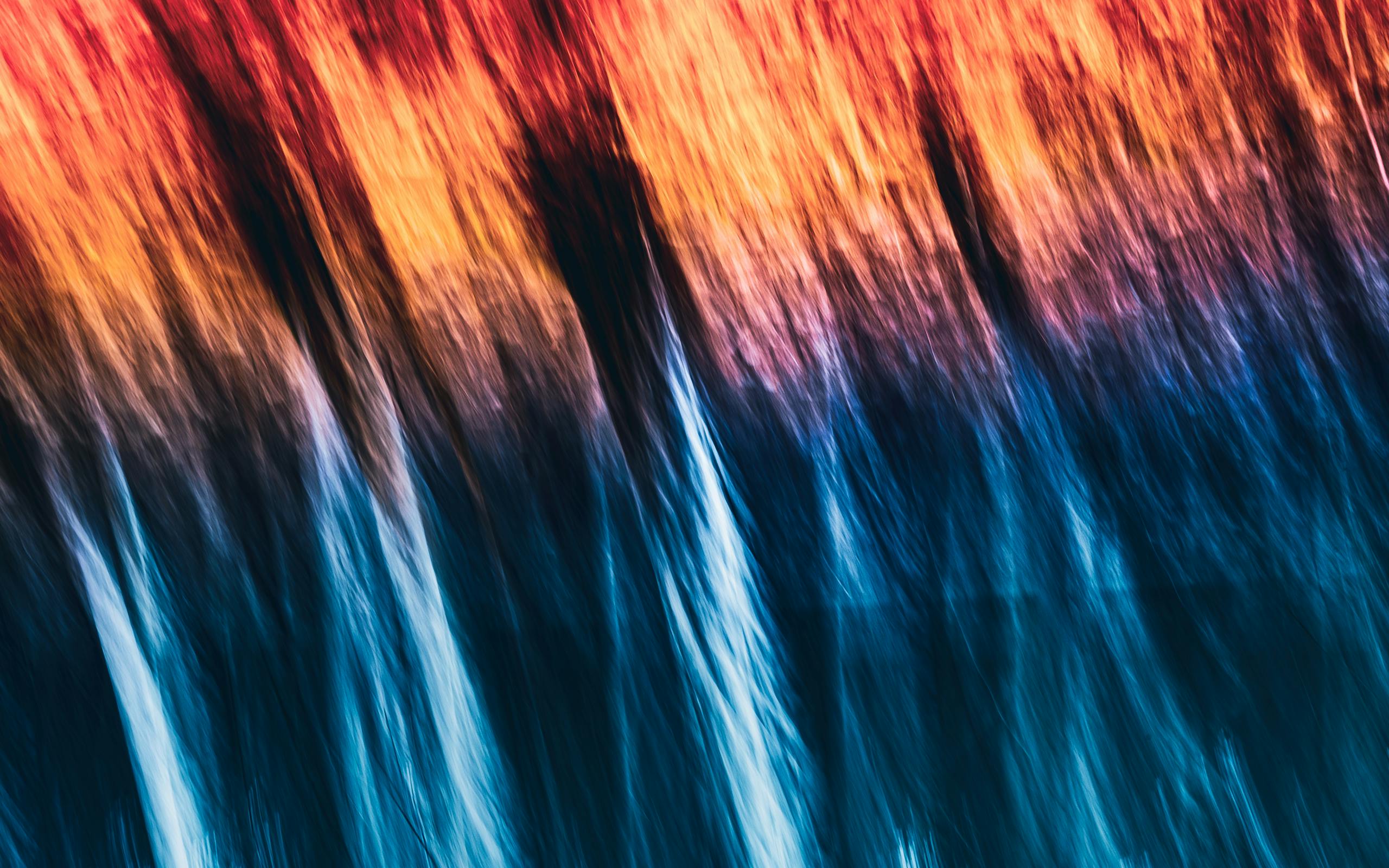 An artistic abstract image with dynamic motion and vibrant hues of red, orange, and blue.